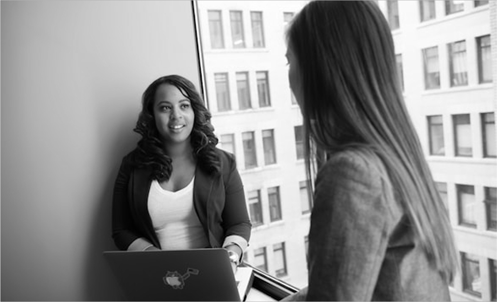 Two woman talking with laptop